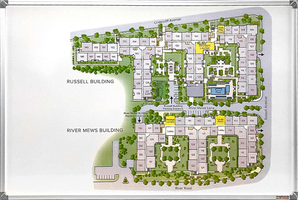 A whiteboard with a framed property map showing two labeled building areas, room numbers, and different amenities of the property.